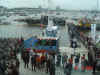 Koningin Beatrix temidden van veel officials en belangstellenden bij de nieuwe catamaran.